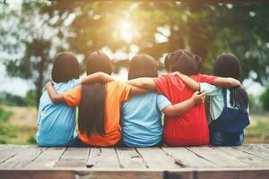 Group of kids friends arm around sitting together photo