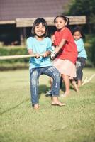 Children group playing tug of war at the park photo