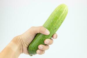 Cucumber in hand isolated on white background with clipping path. photo