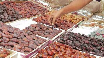 a man is looking at a variety of dates on display in the market video