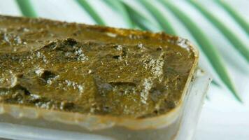 a small container of green paste on a table video