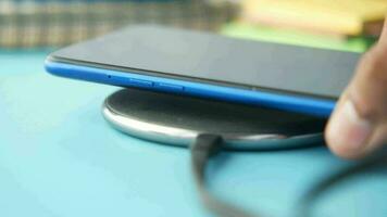 a person holding a wireless charger on a blue table video