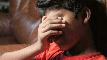 un joven chico es cubierta su ojos con su manos video