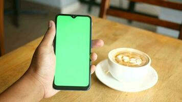 un' mano Tenere un' smartphone con un' verde schermo video