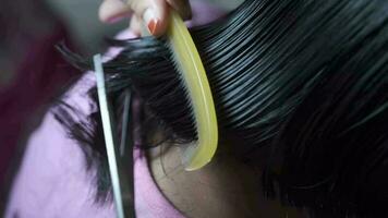 un mujer es corte su pelo con tijeras video