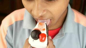 a man eating a cake with a cherry on top video