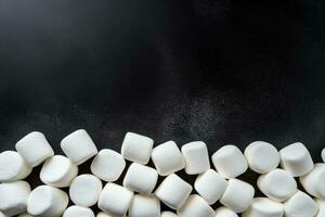 Delicious marshmallows dark background with empty space for text photo