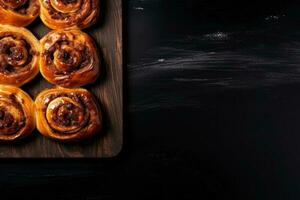 Delicious cinnamon rolls dark background with empty space for text photo