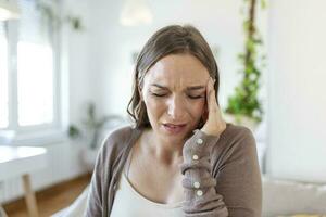 Upset depressed young woman feeling strong headache migraine, sad tired drowsy exhausted woman resting trying to sleep after nervous tension and stress, somnolence concept photo