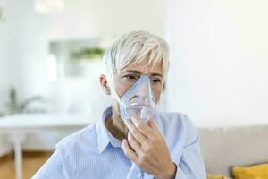 enfermo mayor mujer haciendo inhalación, medicina es el mejor medicamento. enfermo mayor mujer vistiendo un oxígeno máscara y pasando tratamiento para COVID-19. mayor mujer con un inhalador foto