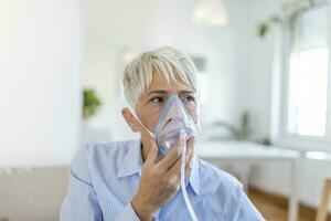 Sick elderly woman on oxygen mask inhalation, pneumonia coronavirus pandemic. ill senior woman wearing an oxygen mask and undergoing treatment. senior woman with covid 19 photo