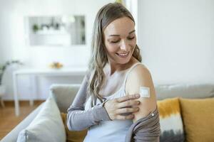 Adhesive bandage on arm after injection vaccine or medicine,ADHESIVE BANDAGES PLASTER - Medical Equipment,Soft focus Adhesive bandage on a Pregnant female brachium after covid-19 vaccination photo