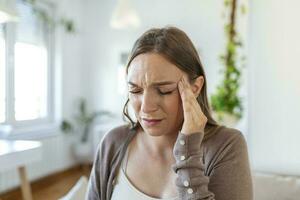 Upset depressed young woman feeling strong headache migraine, sad tired drowsy exhausted woman resting trying to sleep after nervous tension and stress, somnolence concept photo