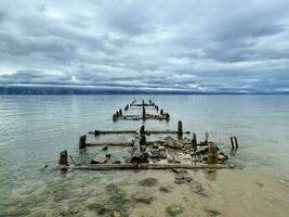 Old ruined pier on the shore of Lake Baikal, Olkhon, Russia photo