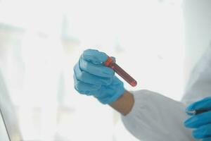 Professional lab. Amazing longhaired medical worker wearing uniform while using microscope during research photo