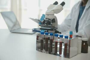 Professional lab. Amazing longhaired medical worker wearing uniform while using microscope during research photo