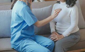 asiático médico mujer visitó paciente mujer a diagnóstico y cheque arriba salud a hogar o privado hospital. hembra paciente explique salud problema y síntomas a médico .salud cuidado prima Servicio a hogar foto