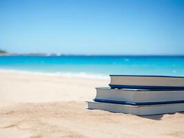 stack book on sand beach over blurred blue sea background. . photo
