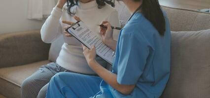 asiático médico mujer visitó paciente mujer a diagnóstico y cheque arriba salud a hogar o privado hospital. hembra paciente explique salud problema y síntomas a médico .salud cuidado prima Servicio a hogar foto