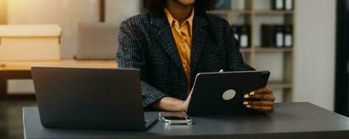 Asian Business woman using calculator and laptop for doing math finance on an office desk, tax, report, accounting, statistics, and analytical research concept photo