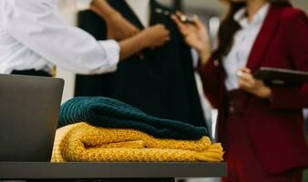 Owner business asian young women fashion designer working on her designer in the showroom, Lifestyle Stylish tailor taking measurements on mannequin for cutting cloths in studio. Small Business photo