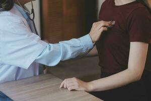 Close-up of stethoscope and paper on background of doctor and patient hands photo