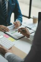 Financial analysts analyze business financial reports on a digital tablet planning investment project during a discussion at a meeting of corporate showing the results of their successful teamwork. photo