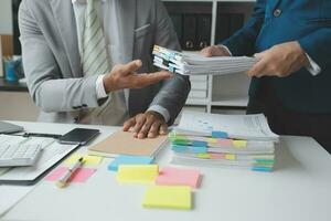 Financial analysts analyze business financial reports on a digital tablet planning investment project during a discussion at a meeting of corporate showing the results of their successful teamwork. photo