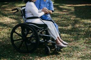 young asian physical therapist working with senior woman on walking with a walker photo