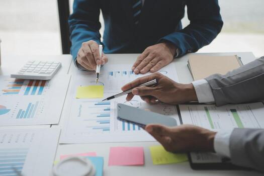 Financial analysts analyze business financial reports on a digital tablet planning investment project during a discussion at a meeting of corporate showing the results of their successful teamwork. photo