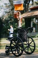 young asian physical therapist working with senior woman on walking with a walker photo