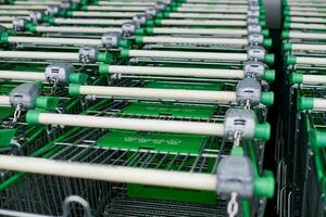 Row of parked shopping carts of trolleys in supermarket photo