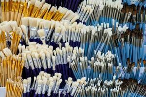 New artistic paint brushes on shelf in stationery shop photo