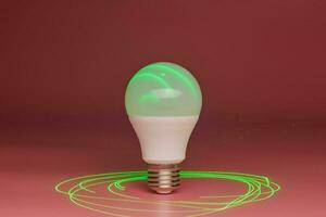 Energy saving light bulb, green laser beam around, copy space. Minimal idea concept. photo