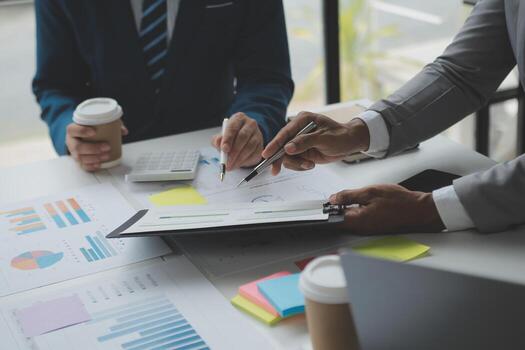 Financial analysts analyze business financial reports on a digital tablet planning investment project during a discussion at a meeting of corporate showing the results of their successful teamwork. photo