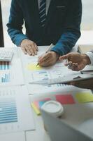 Financial analysts analyze business financial reports on a digital tablet planning investment project during a discussion at a meeting of corporate showing the results of their successful teamwork. photo