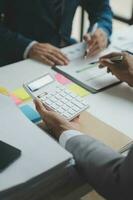 Financial analysts analyze business financial reports on a digital tablet planning investment project during a discussion at a meeting of corporate showing the results of their successful teamwork. photo