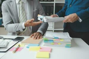 Financial analysts analyze business financial reports on a digital tablet planning investment project during a discussion at a meeting of corporate showing the results of their successful teamwork. photo