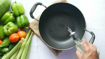 a person is pouring cooking oil on a frying pan video