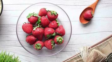 a bowl of strawberries with wooden spoon video