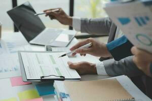 Financial analysts analyze business financial reports on a digital tablet planning investment project during a discussion at a meeting of corporate showing the results of their successful teamwork. photo