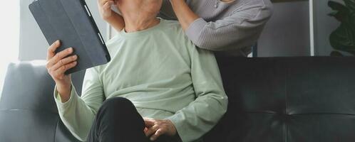 Happy mature couple using laptop at home photo