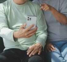 Embraced mature couple surfing the Internet on laptop at home photo