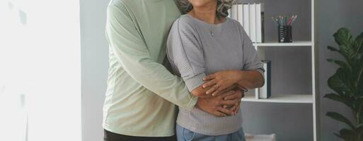 Embraced mature couple surfing the Internet on laptop at home photo