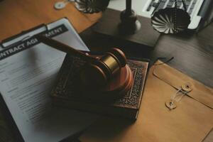 Business and lawyers discussing contract papers with brass scale on desk in office. Law, legal services, advice, justice and law concept picture with film grain effect photo