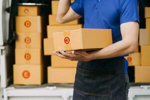 Asian delivery man in cargo van checking boxes. photo