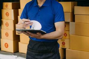 Asian delivery man in cargo van checking boxes. photo