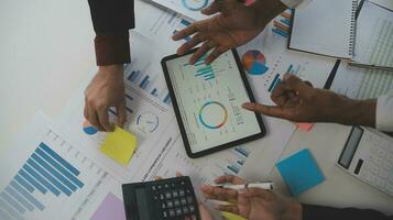los analistas financieros analizan los informes financieros de negocios en un proyecto de inversión de planificación de tabletas digitales durante una discusión en una reunión de empresas que muestran los resultados de su exitoso trabajo en equipo. foto