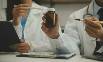 Doctor sitting at desk and writing a prescription for her patient photo