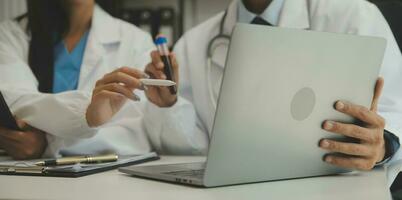 médico sentado a escritorio y escritura un prescripción para su paciente foto